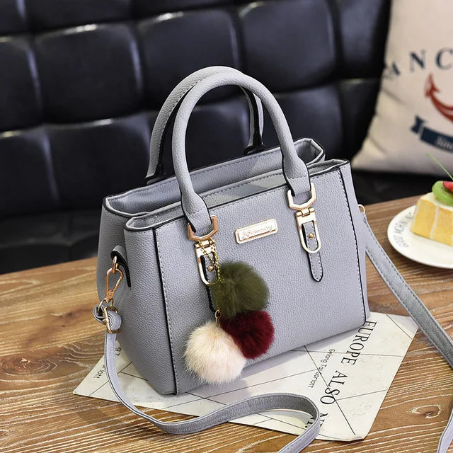 Structured Pebbled Leather Top-Handle Tote Bag with Pom-Pom Charm & Crossbody Strap